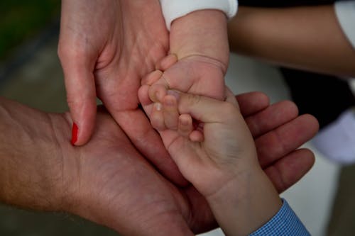 Free Parents Holding Hand of Their Baby  Stock Photo