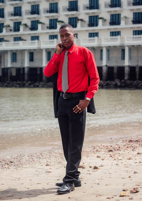 Man in Red Shirt Standing on Lake Shore