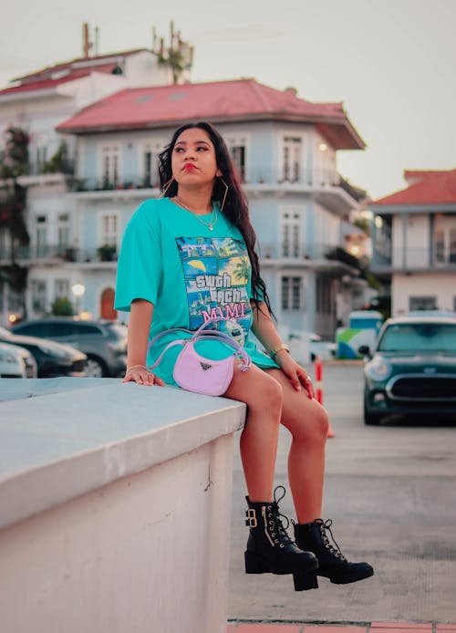 Woman Sitting on a Wall by the Street