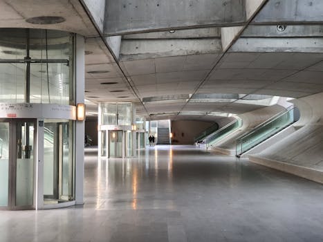Explore the sleek and futuristic design of an urban subway station with concrete structures and glass elements.