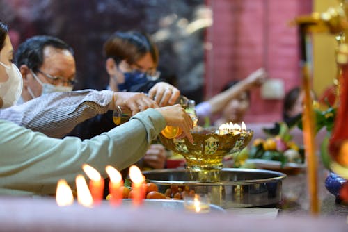 People Pouring Oil Through an Ornate Funnel