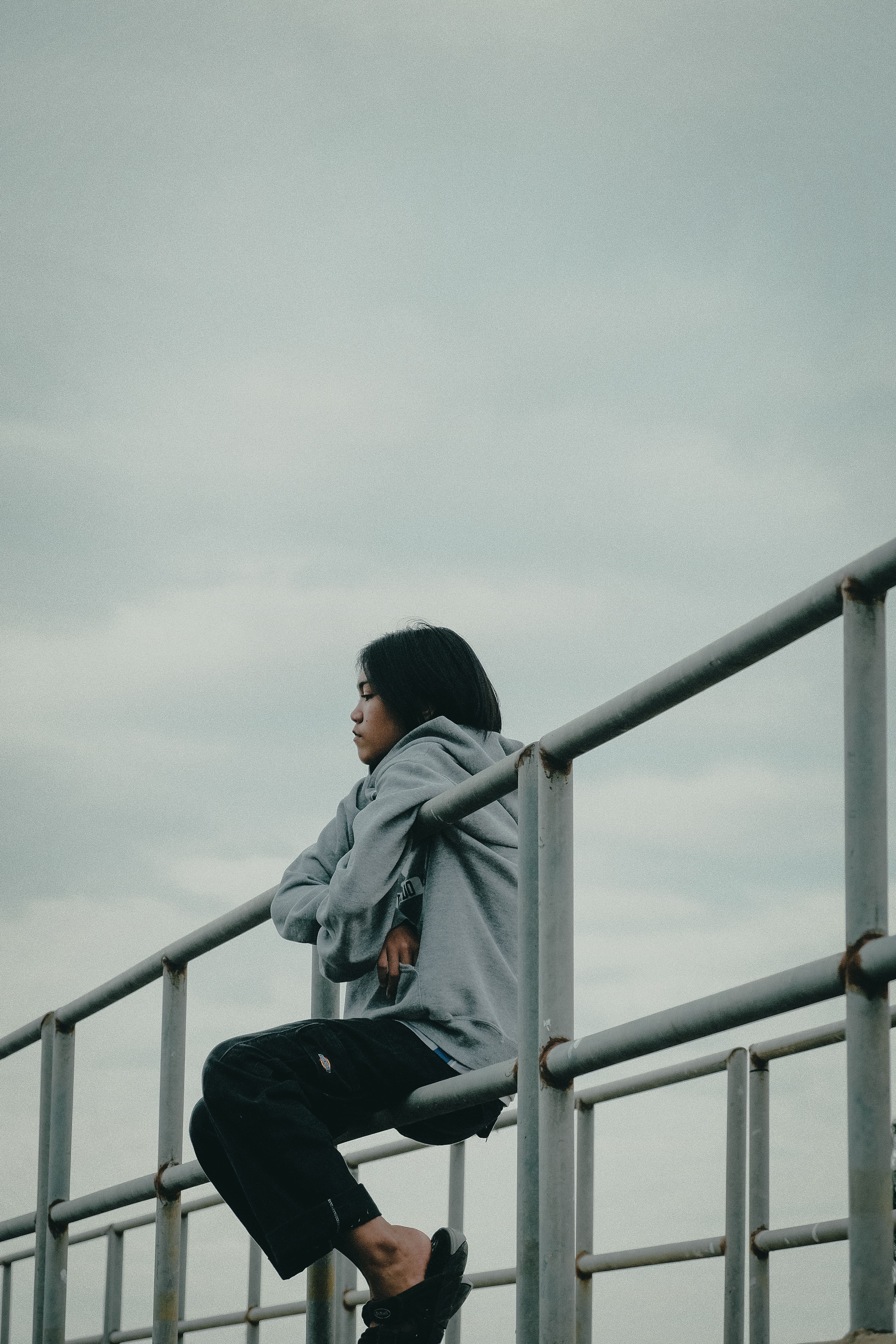 Young Woman Sitting on the Railing · Free Stock Photo