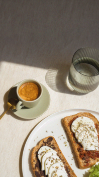 A bright morning setup featuring toast with cheese and a cup of coffee.