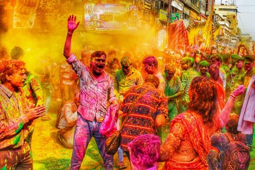 People enjoying a colorful Holi celebration in Kolkata, India, showcasing vibrant powders and lively street atmosphere.