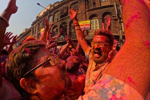 Free People joyfully celebrate Holi in Kolkata, showered with colorful powder and smiles. Stock Photo