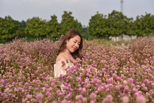 Young Woman Standing in a Field with Purple Flowers