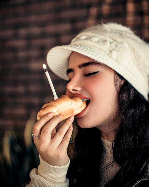 Woman in Hat Eating with Eyes Closed