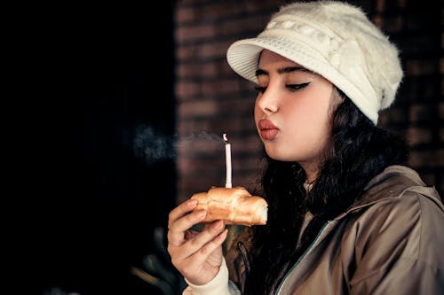 Woman in Hat Blowing Candle