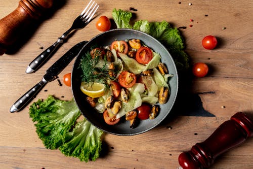 A Salad in a Bowl with Ingredients Scattered around the Table 