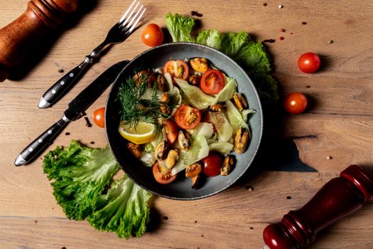 A vibrant salad featuring cherry tomatoes, mussels, and fresh lettuce with a lemon garnish. Perfect for a healthy meal.