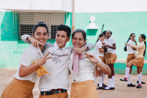 Free Happy group of teenage school friends embracing and posing outdoors. Stock Photo