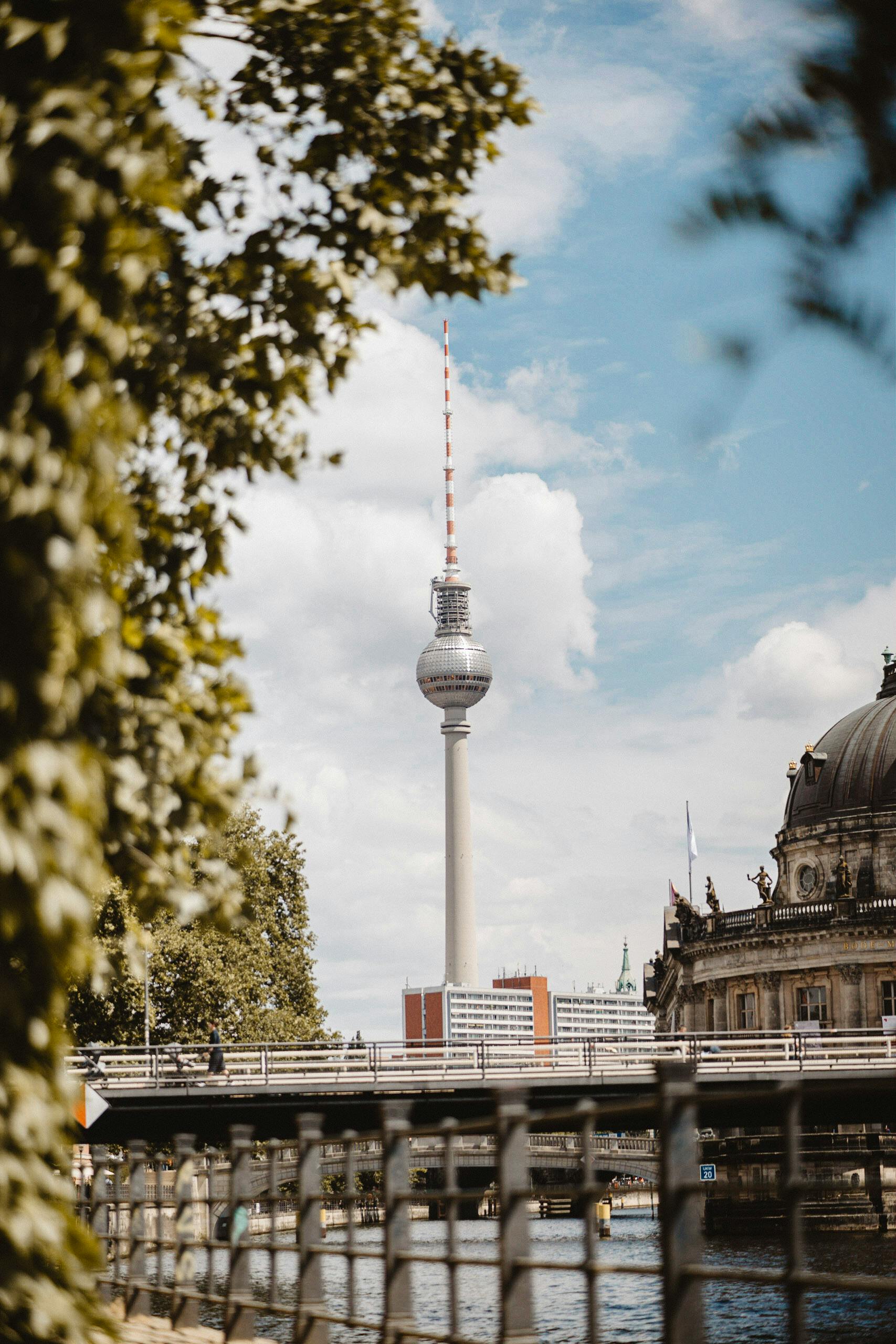 Iconic view of Berlin's Fernsehturm with river and architecture in the foreground.