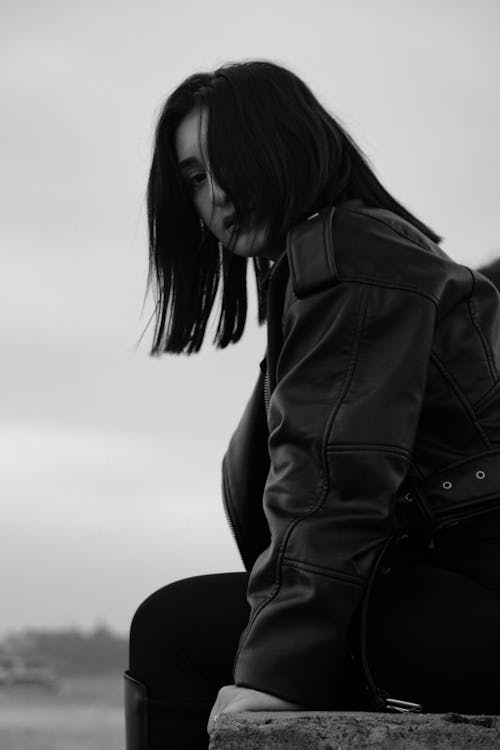 Woman Sitting in Jacket in Black and White