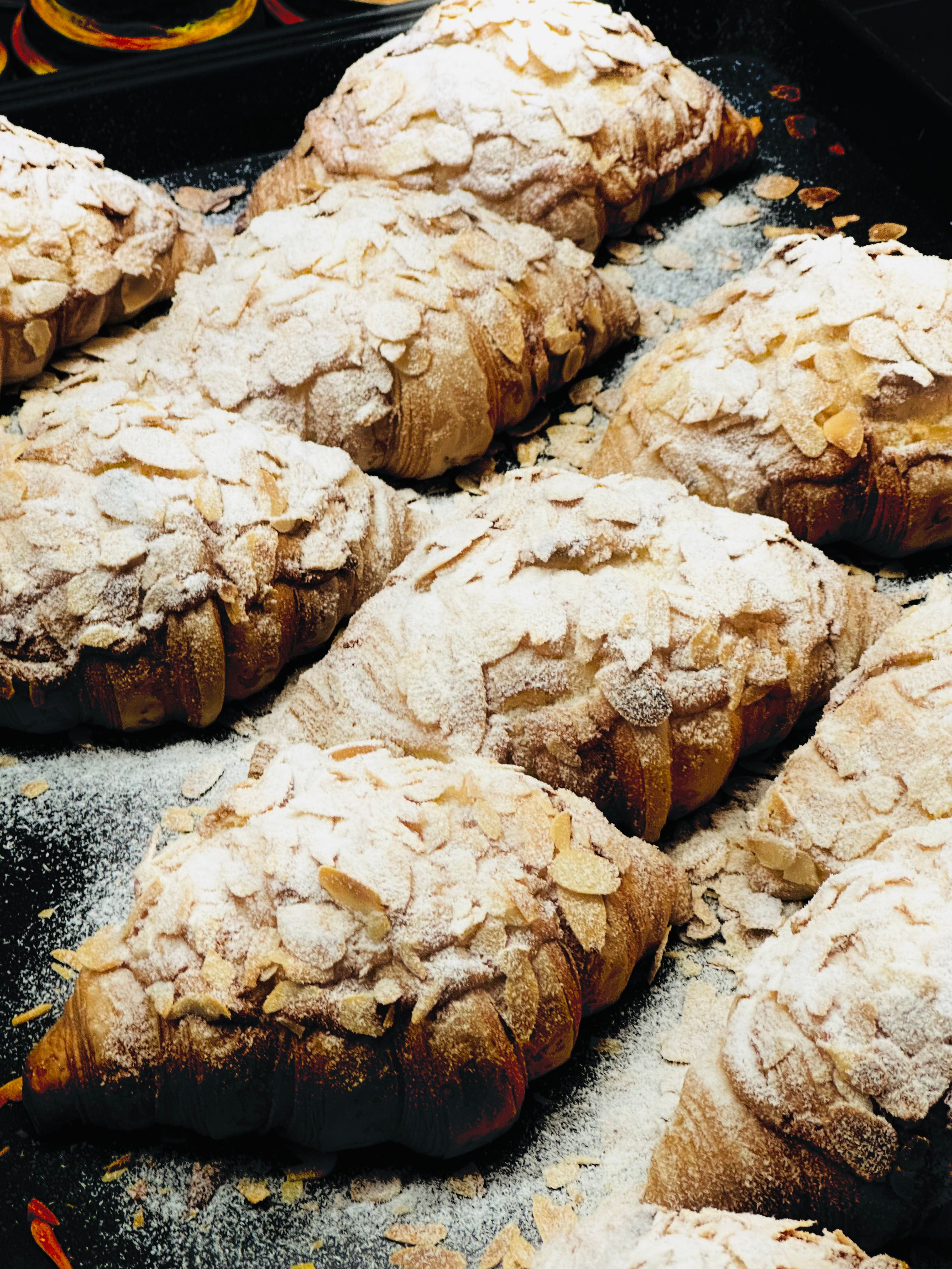 Delicious almond croissants dusted with powdered sugar, captured in a Beijing bakery.