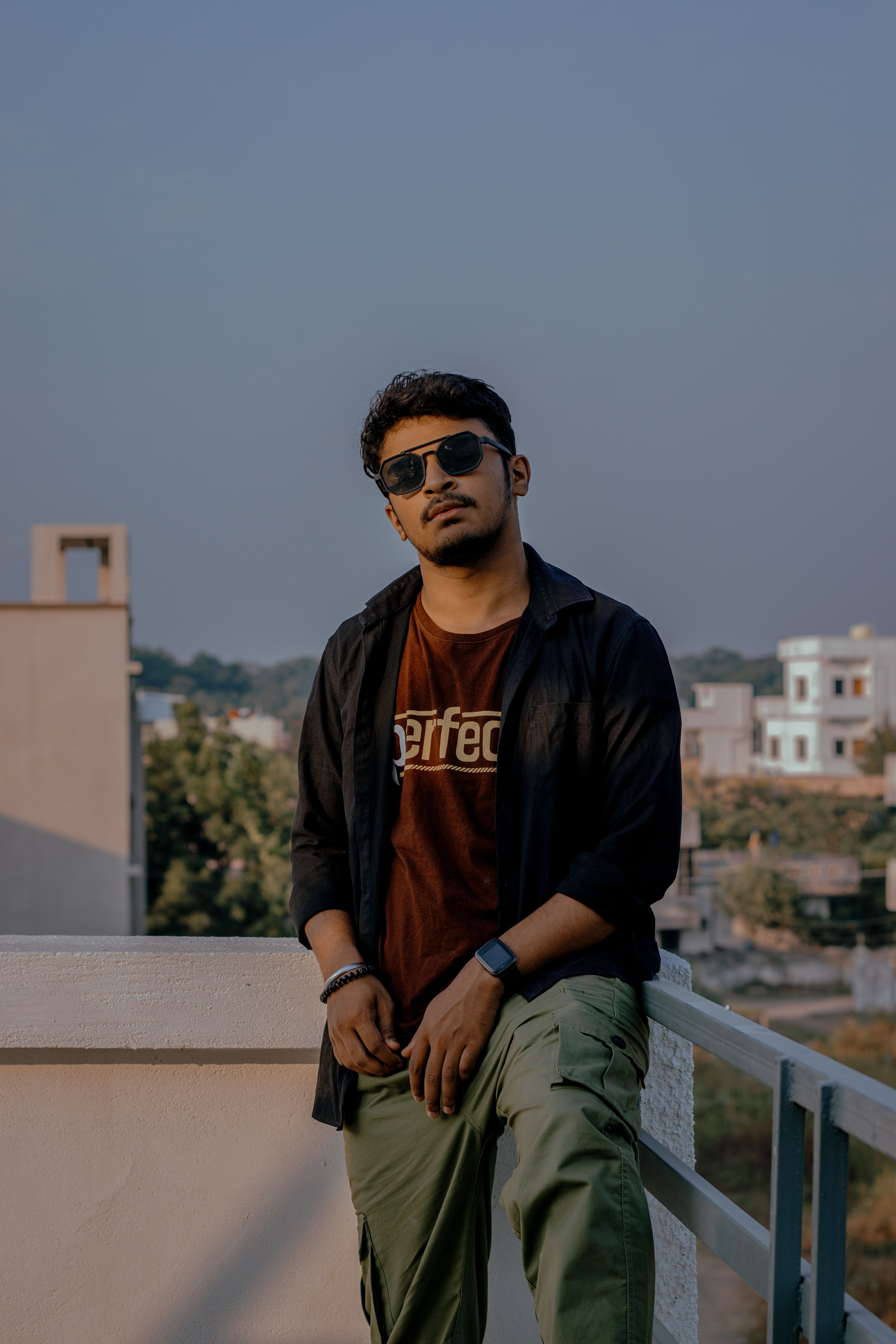 Outdoor portrait of a man in sunglasses shot at 50mm, the focal length at the center of the 50mm vs 85mm portraits debate