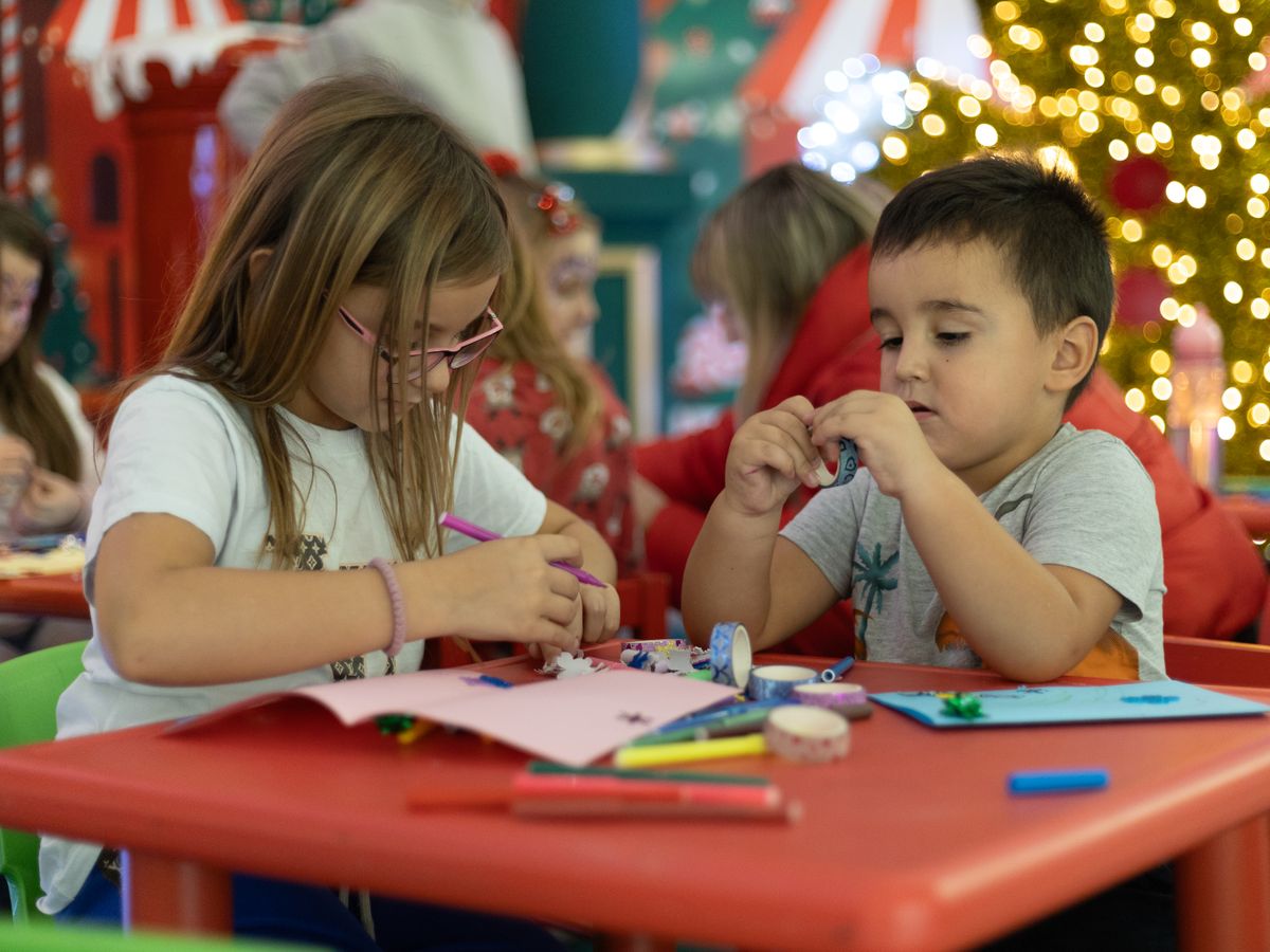 Children making Christmas crafts at a table
