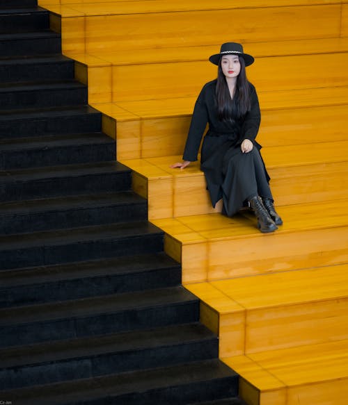 Model in Black Coat and Hat Posing on Steps