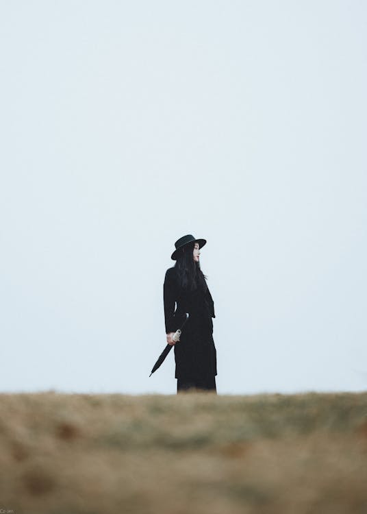 Woman Standing on Sand, Wearing Hat