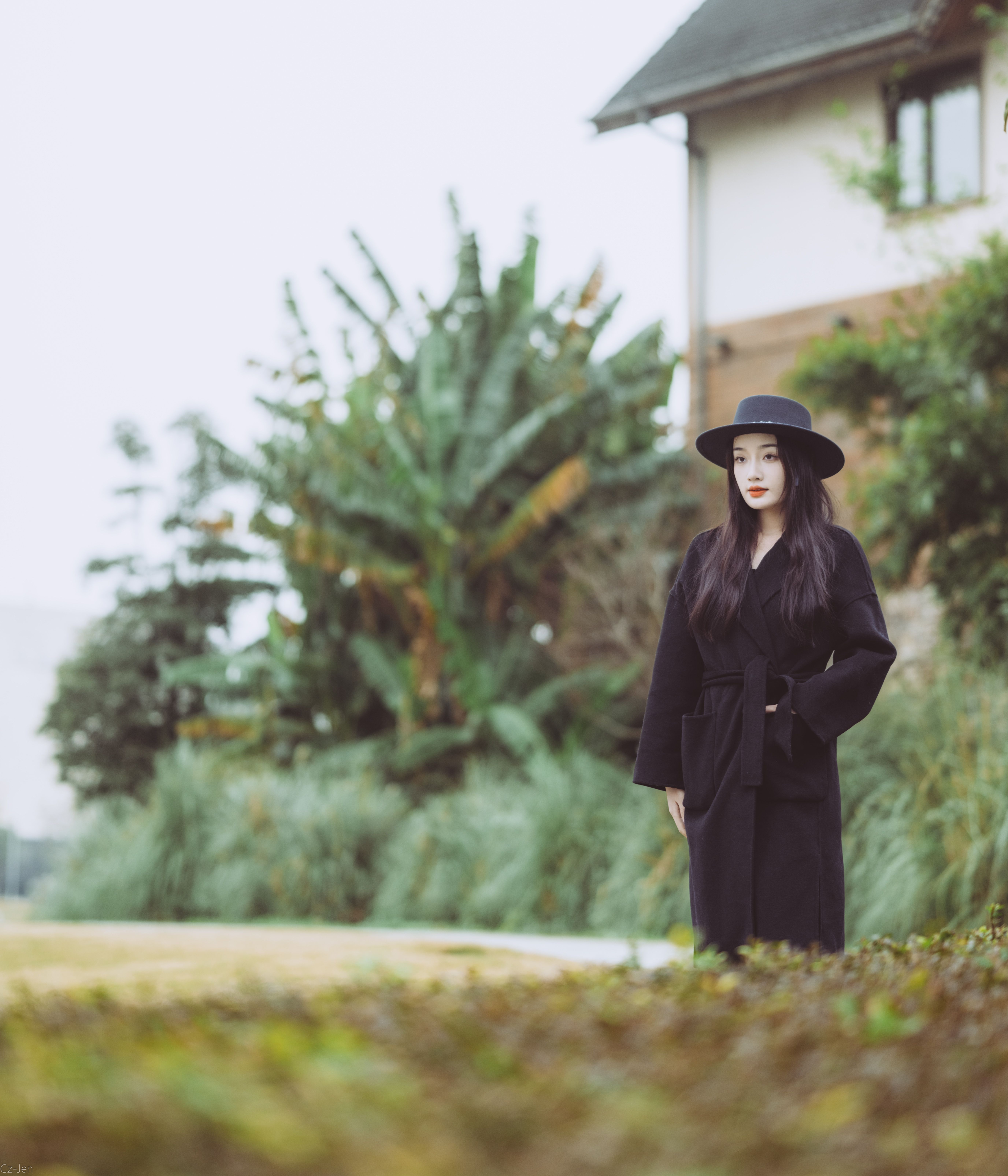 Fashion portrait of a woman in a black coat and hat outdoors in Changsha, China.