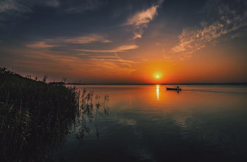 無料 日没時に旅行するボートに乗っている人 写真素材