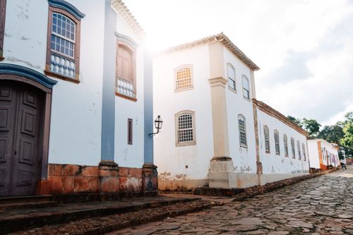 Free Cobbled street in Tiradentes, Brazil, showcasing colonial architecture bathed in sunlight. Stock Photo
