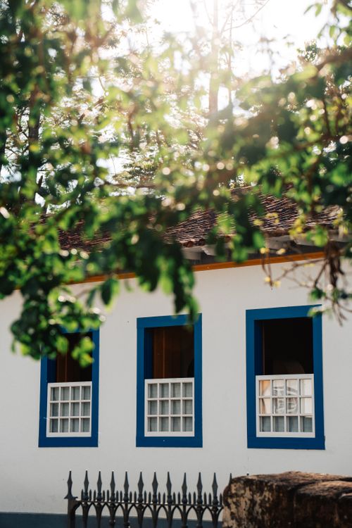 Free Colonial architecture with blue accents and green foliage in Tiradentes, Brazil. Stock Photo