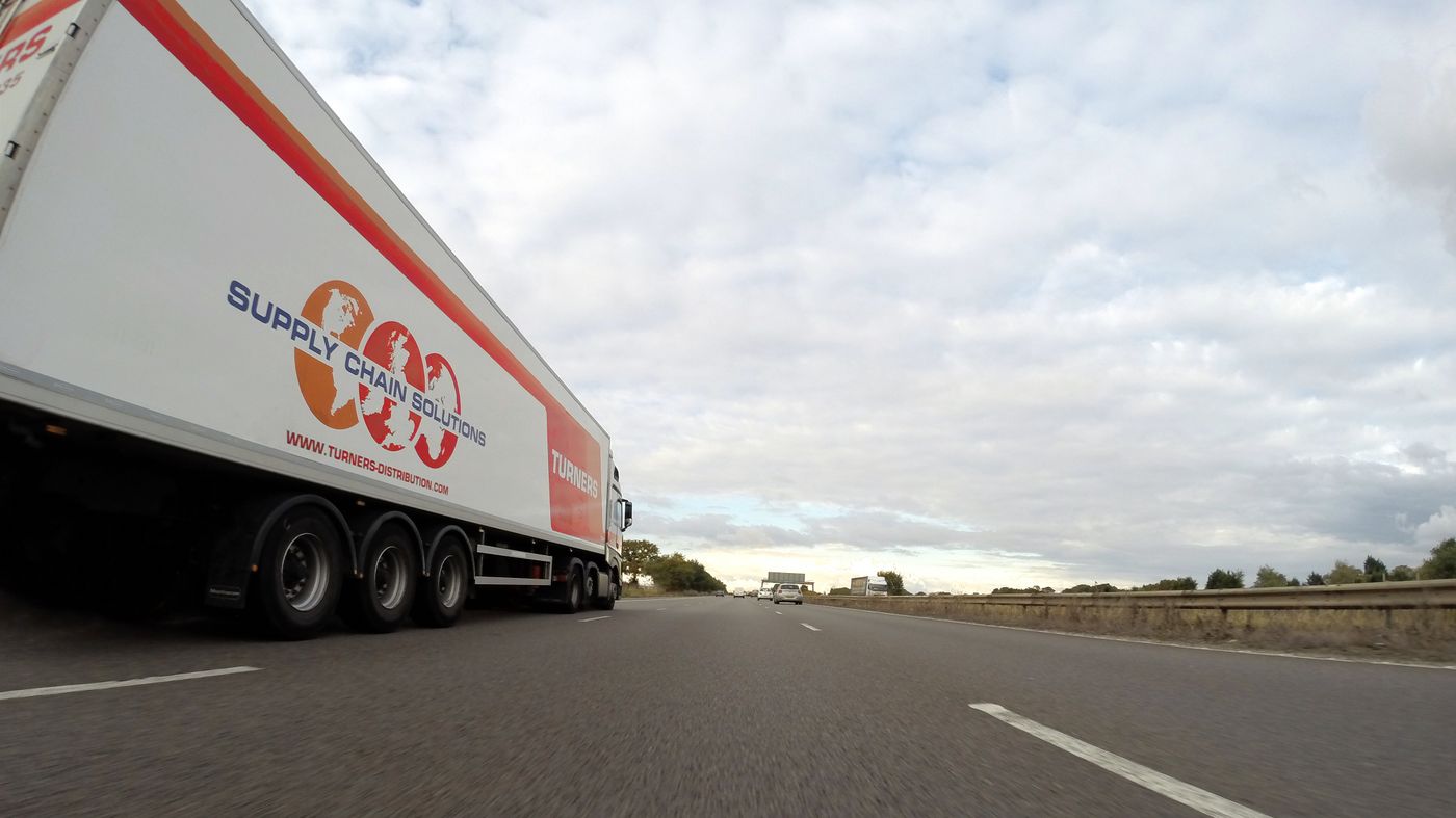 White trailer truck traveling on a roadway