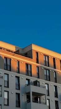 Sunlit facade of a modern apartment building in Berlin, showcasing urban architecture.