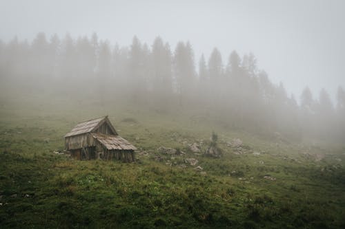 Wooden Barn on a Hill Covered with Fog 