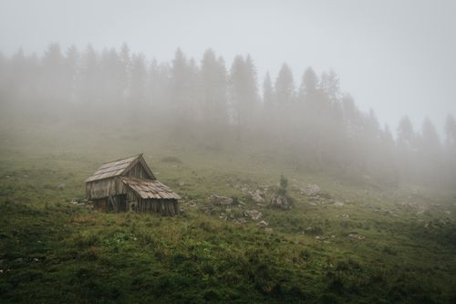 Timber hut on a misty hillside, photo by Elias Tigiser on Pexels