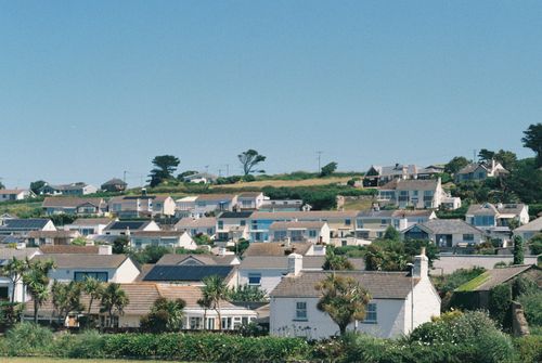 Free Scenic view of a quaint coastal village with white houses under a vibrant blue sky. Stock Photo