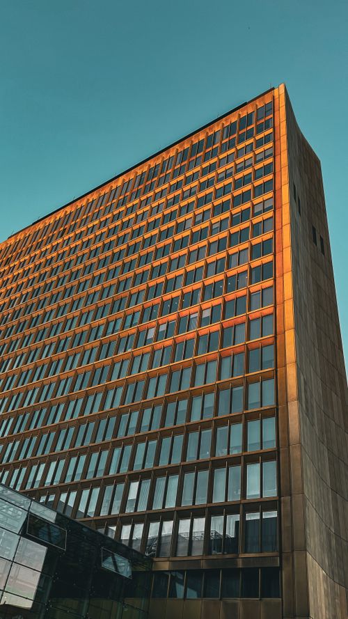 Free A towering modern office building with reflective windows in Berlin, showcasing architectural elegance and symmetry. Stock Photo
