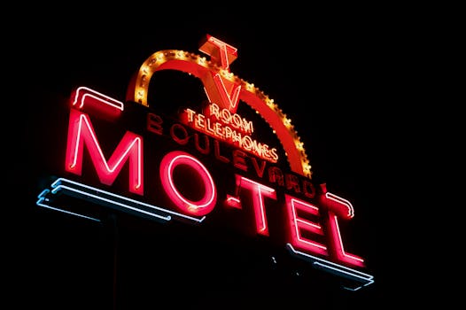 Colorful neon sign of Boulevard Motel glowing against a dark night sky, emphasizing urban nightlife.