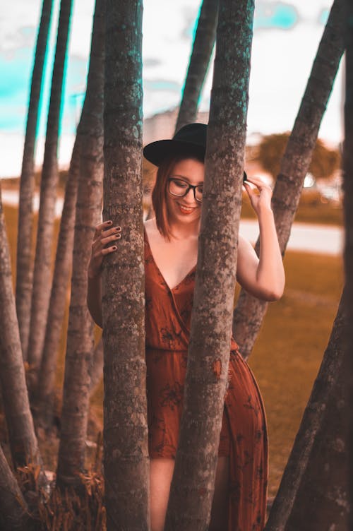 Woman Wearing Brown Dress Holding a Tree