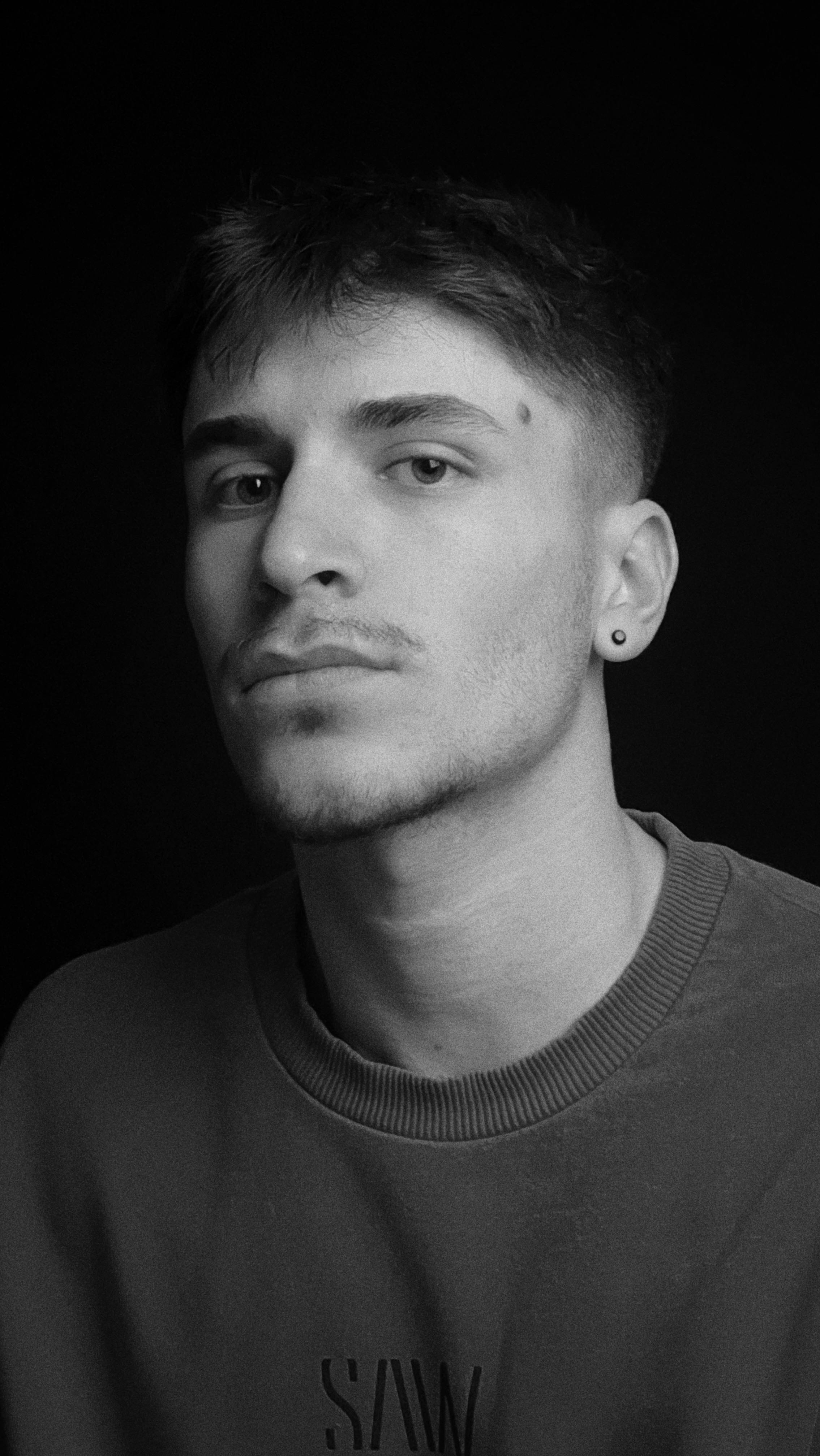 Classic monochrome portrait of a thoughtful young man with stubble.