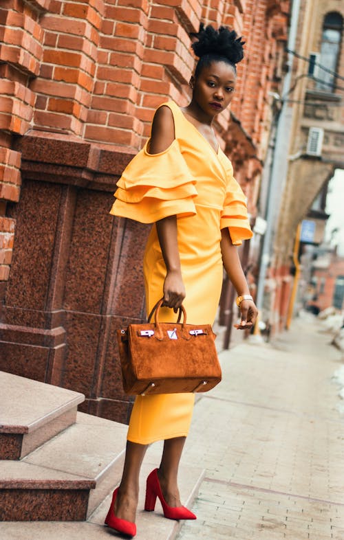 Woman Standing and Holding Brown Handbag