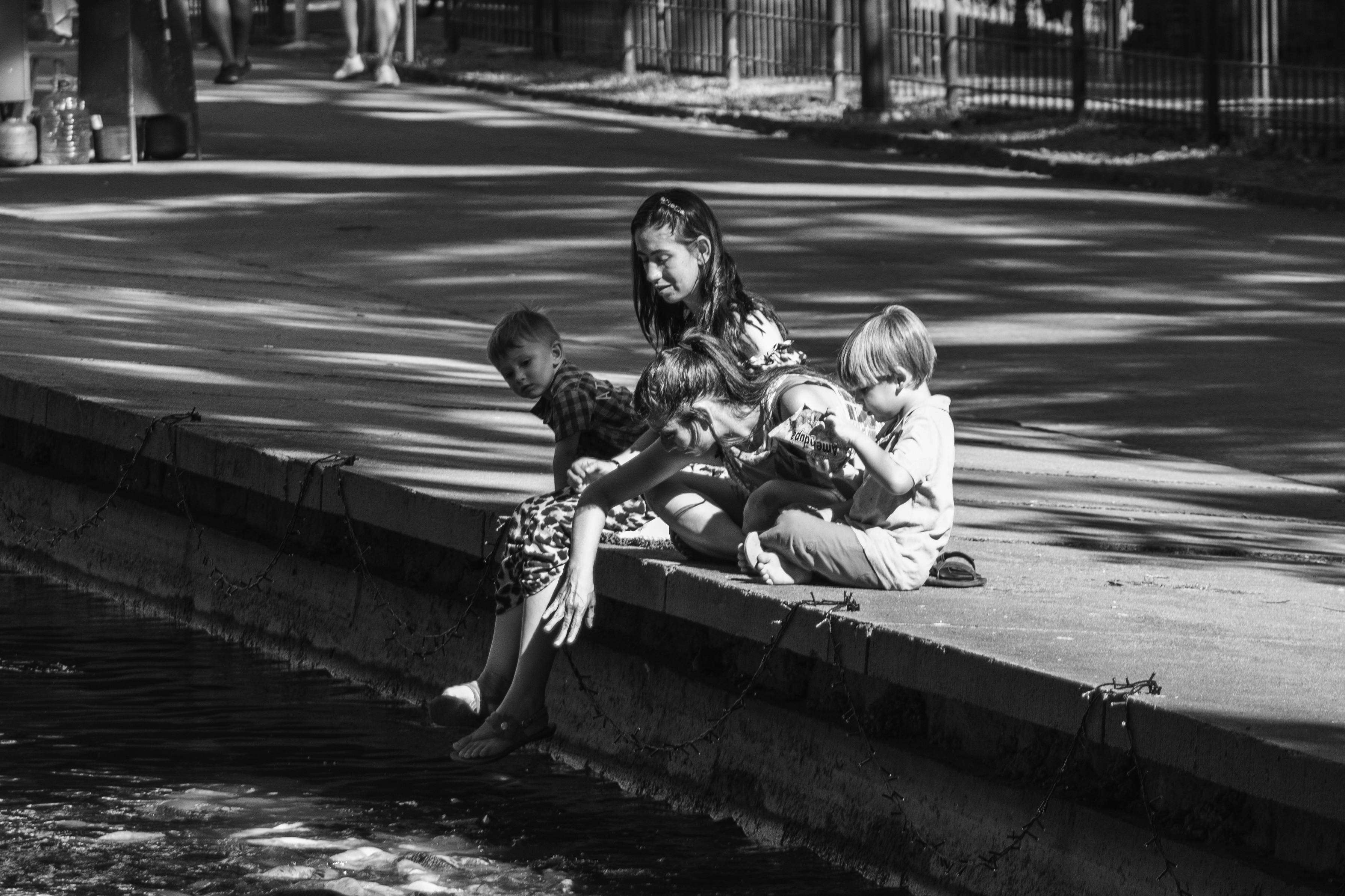 A group of children sitting by the water enjoying a peaceful moment.