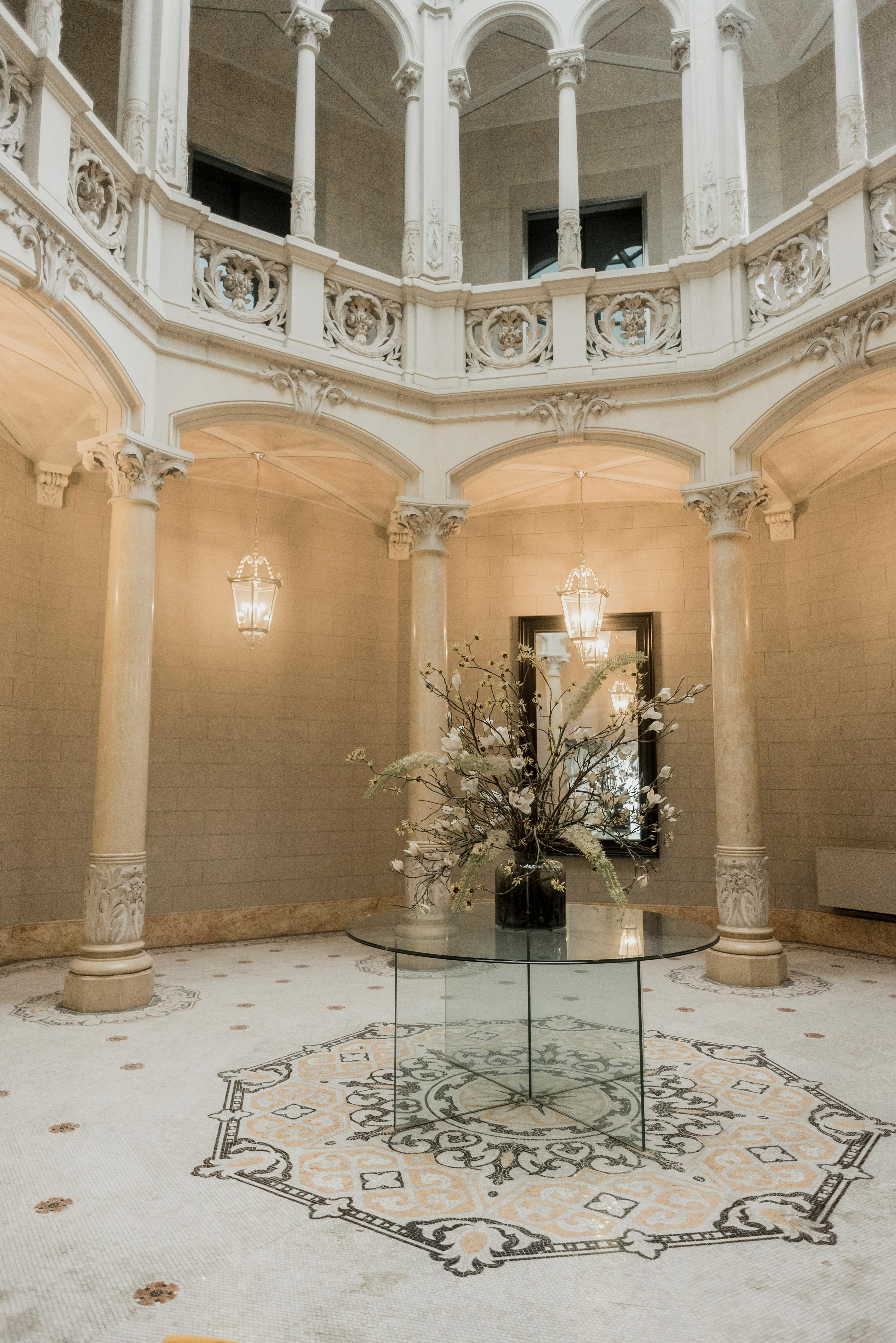 Elegant palace interior featuring marble columns and a decorative centerpiece.