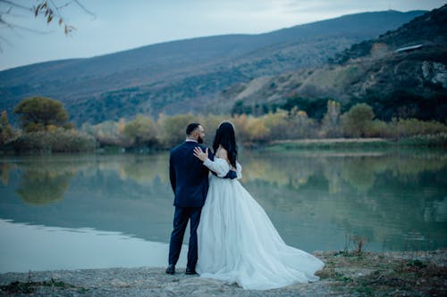 Newlyweds Standing by a Lake