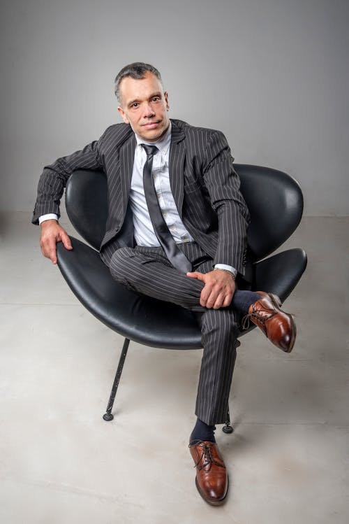 Man in Suit Sitting on Chair