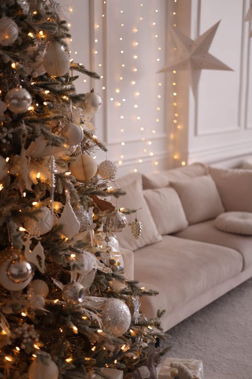 Free Cozy living room with a beautifully decorated Christmas tree and warm fairy lights. Stock Photo
