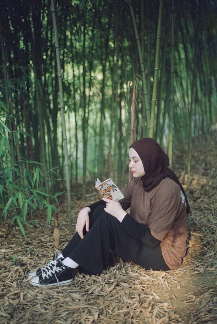 Girl Reading A Book In A Bamboo Forest