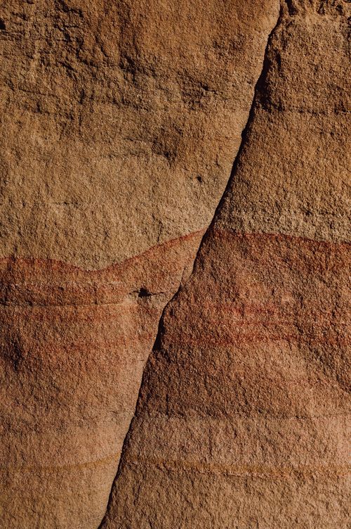 Free Close-up of a textured sandstone wall showing natural color variations and patterns. Stock Photo
