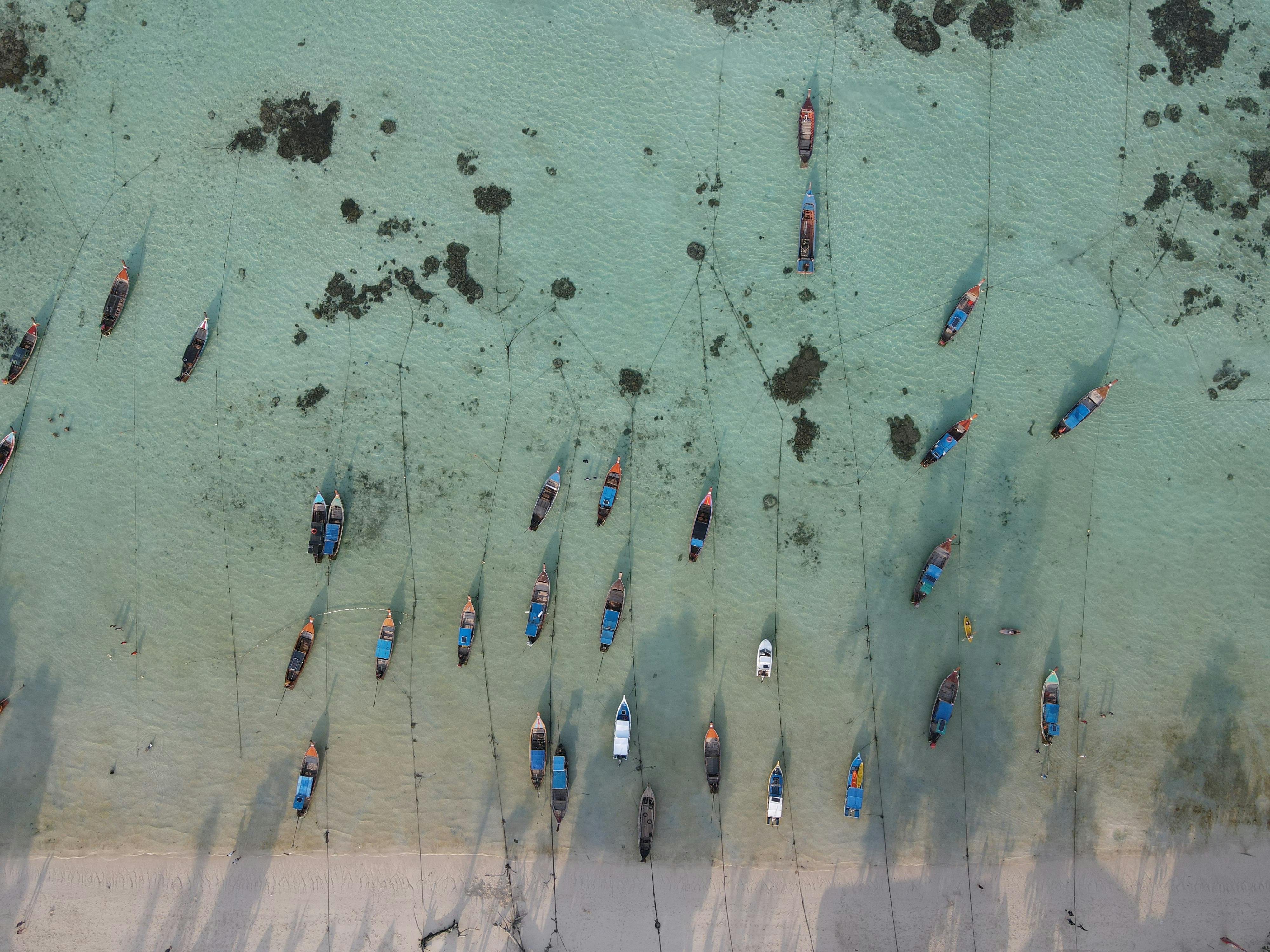 Stunning aerial shot of boats anchored along the clear waters of Ko Tarutao, Thailand.