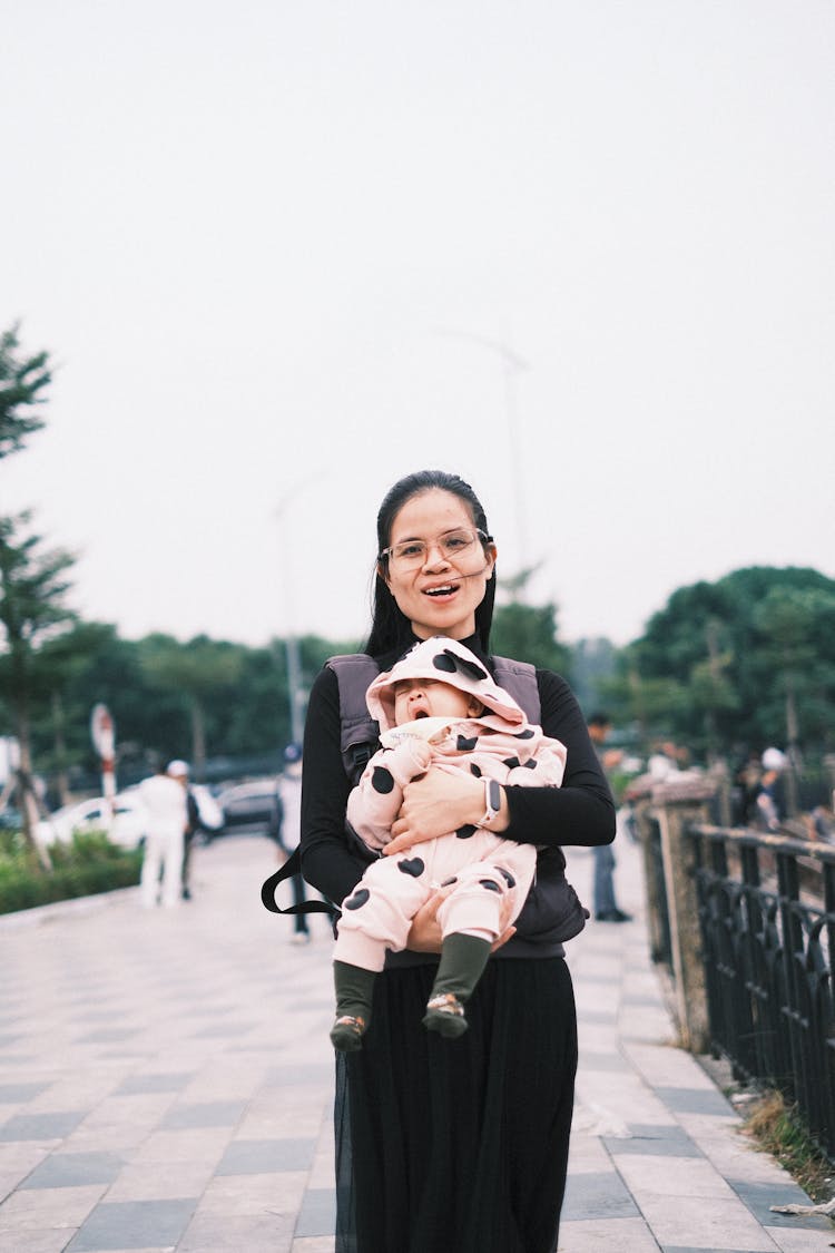 Smiling Brunette Mother With Daughter In Hands