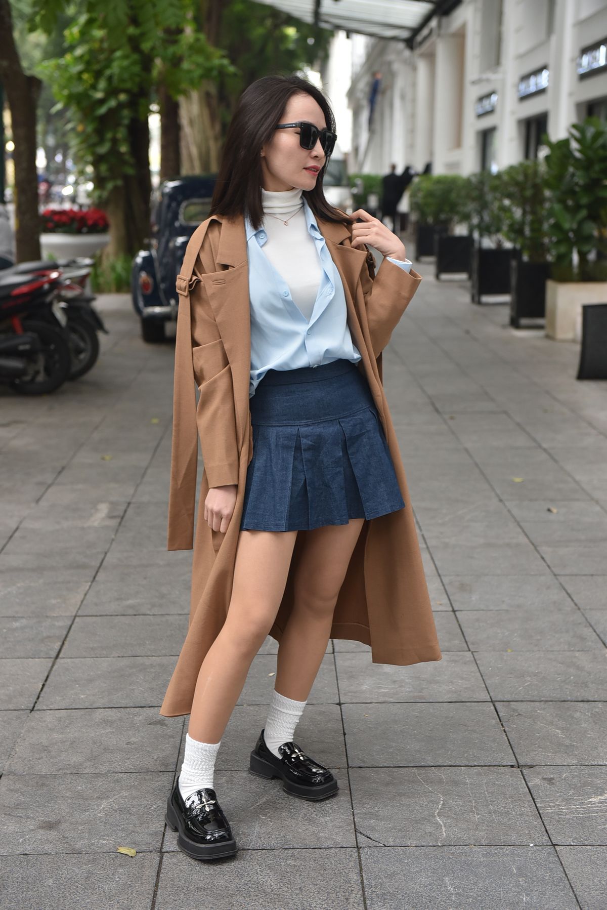 Mini Skirt with Tights Outfits for Women — 7 Fall Looks with Boots and Knits Woman in a blue coat and pleated skirt in the city