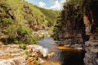 一条风景如画的河流，流经被郁郁葱葱的绿植和蓝天环绕的岩石峡谷