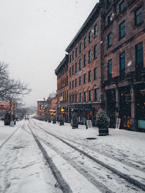 Free Captivating snowy city street scene captured at dusk, showcasing historic architecture and urban charm. Stock Photo