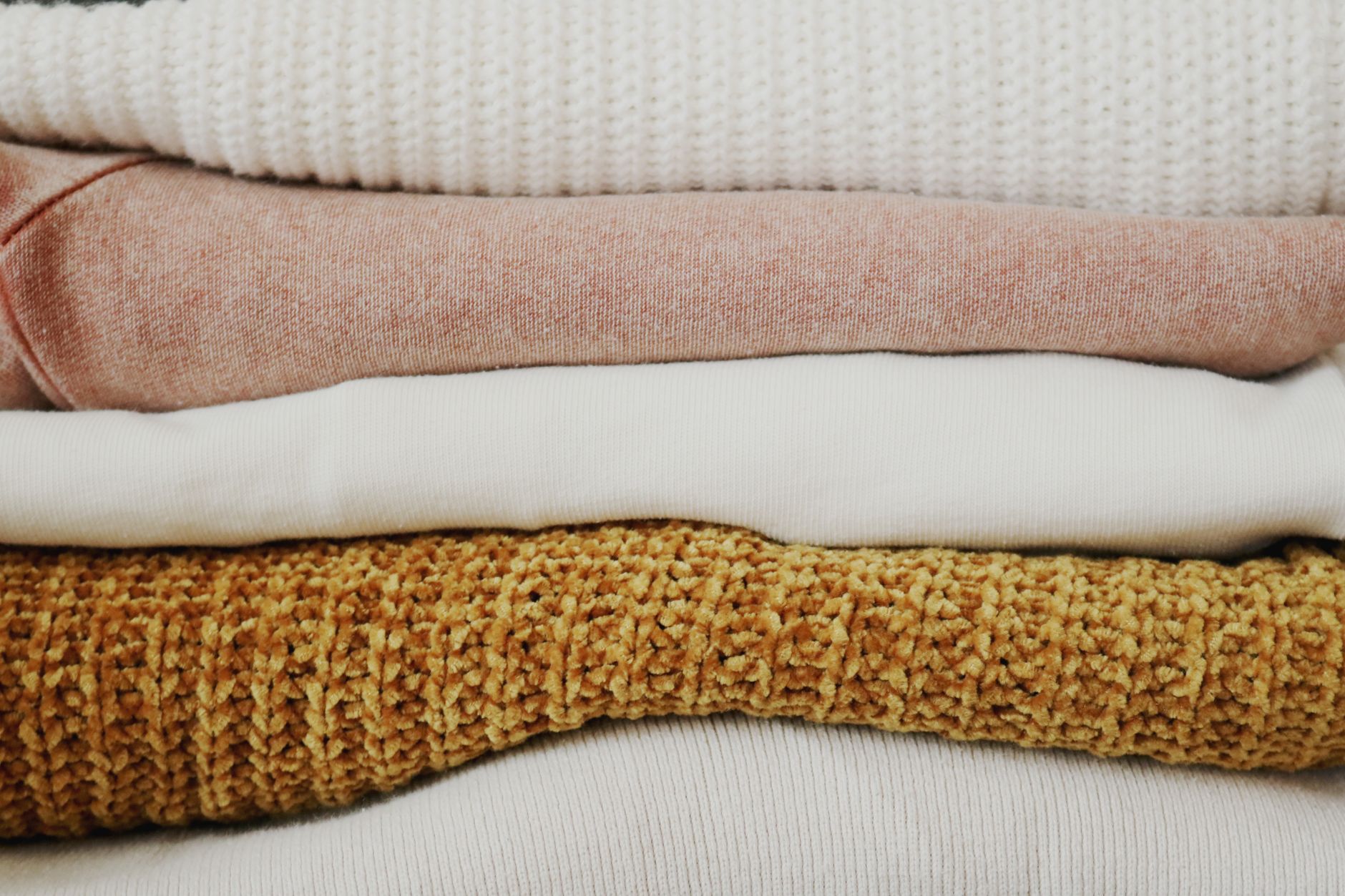 A wool coat folded with a visible crease line across the sleeve from long-term compression