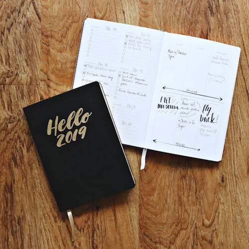 Free Black Hello 2019 Notebook on Brown Wooden Surface Stock Photo